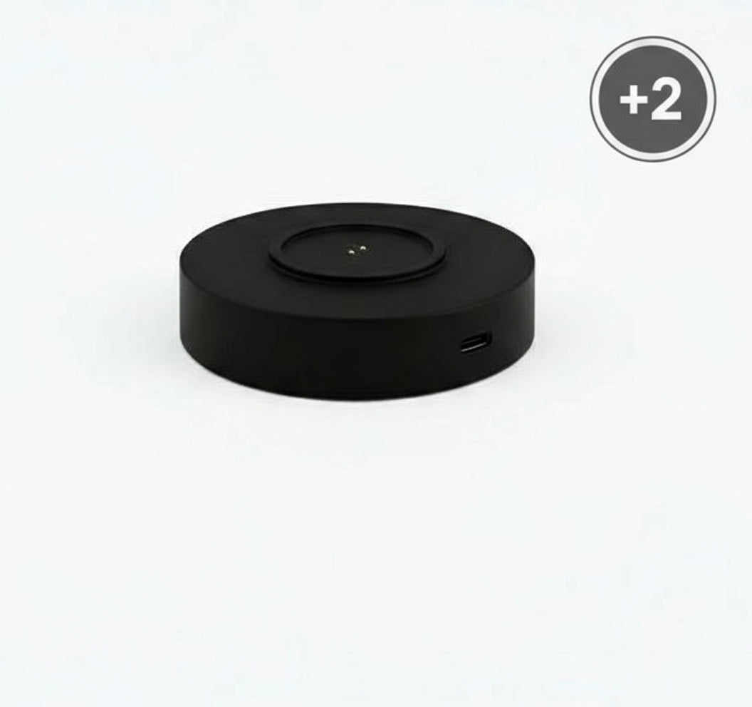 Black circular device with a USB port on a white background