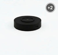 Black circular device with a USB port on a white background